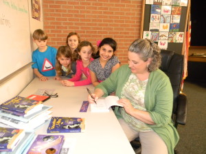Signing books for students at The Branch School.